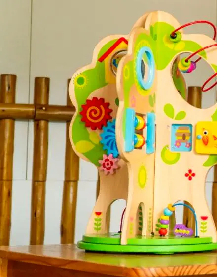 Brinquedo educativo de madeira colorido sobre a mesa do espaço dos bebês