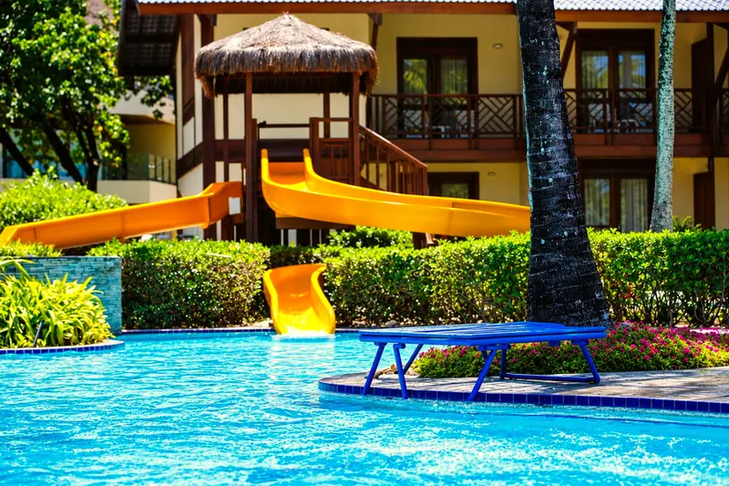 Toboáguas amarelos sobre a piscina infantil diante do prédio