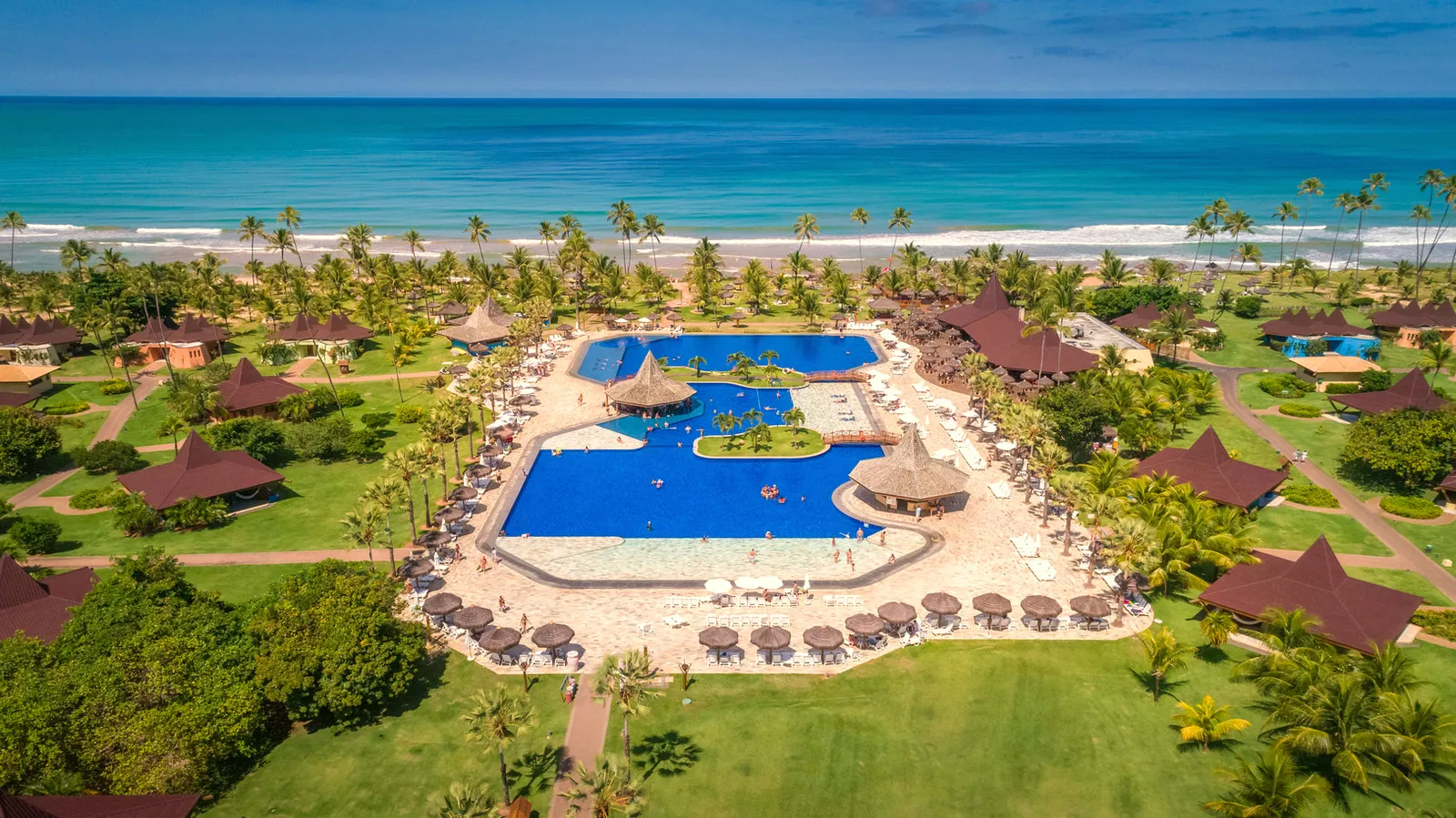 Vista aérea do Vila Galé Marés, com as piscinas, os jardins e o mar de Guarajuba